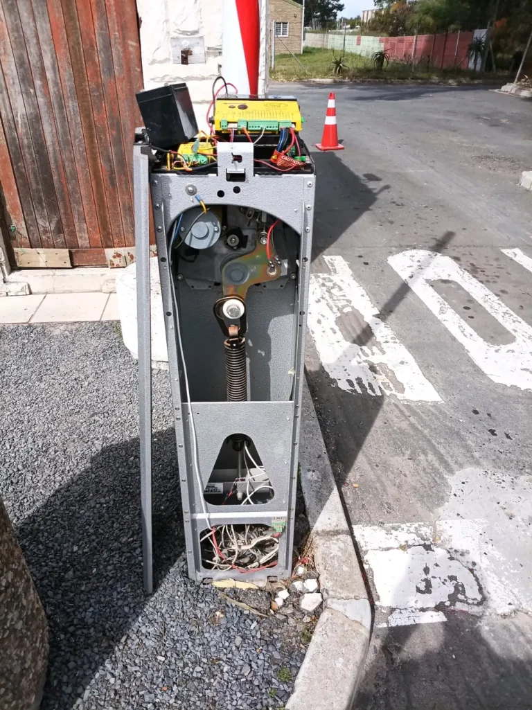 Boom-barrier cabinet with the drive mechanism and control components exposed during maintenance.