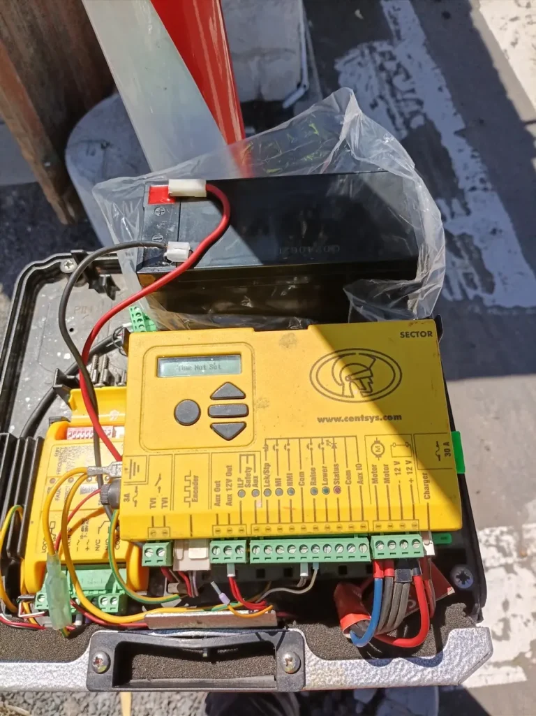 Centurion SECTOR boom-gate control board and backup battery during diagnostic work.